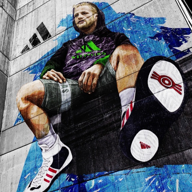 Artwork of a wrestler on the side of a building.